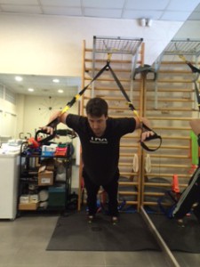 Entrenador de TRX mostrando ejercicios para la Recuperación de hombro mediante ejercicios de TRX.  